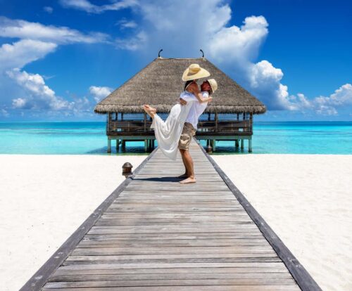 couple embracing on a wooden pier in the Maldives