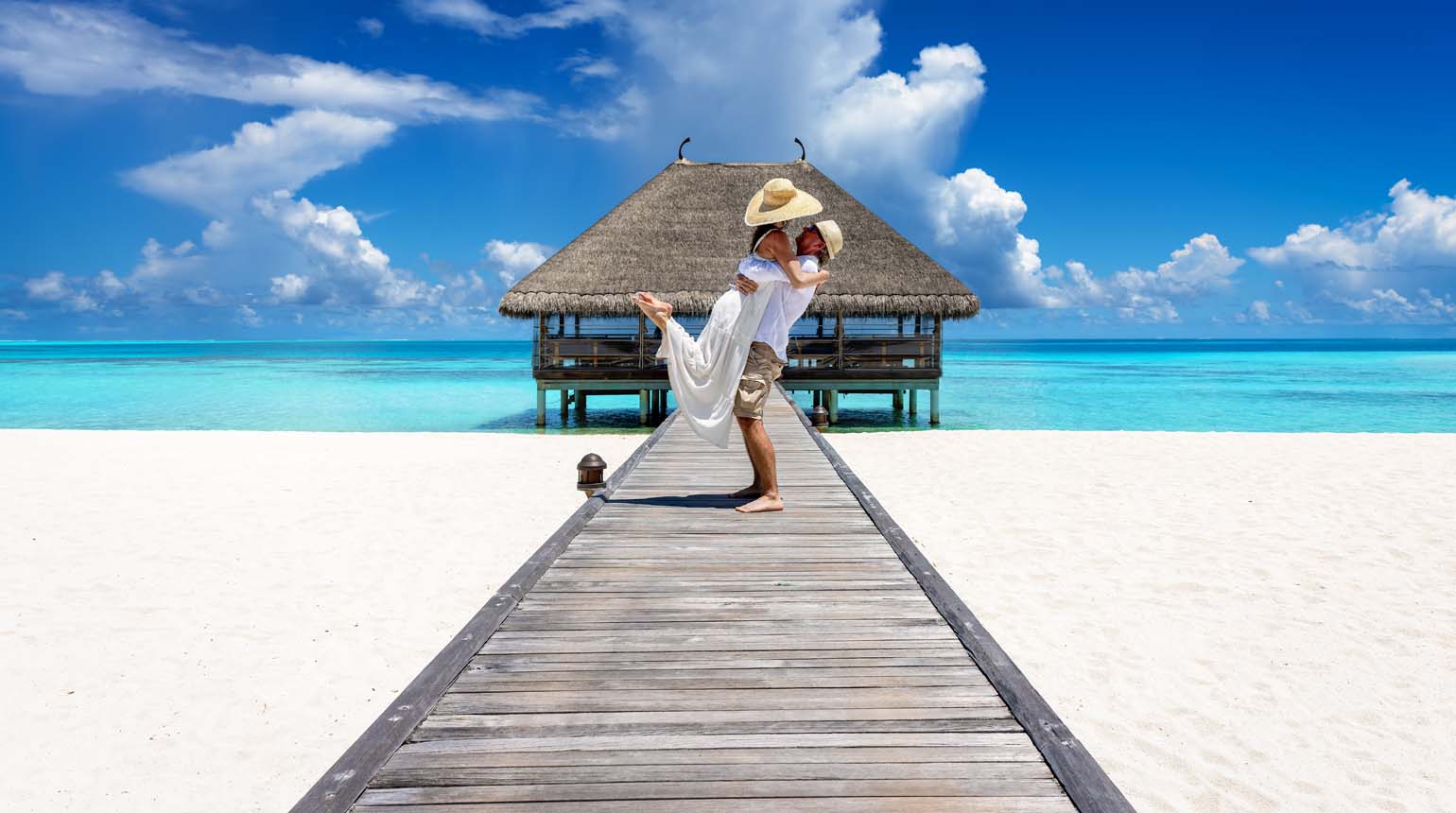 couple embracing on a wooden pier in the Maldives couple embracing on a wooden pier in the Maldives
