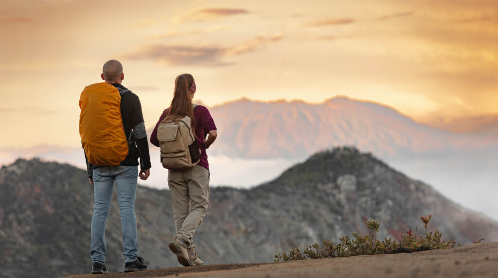 Couple of young hikers with backpacks experiencing a Sunrise Trek in Bali