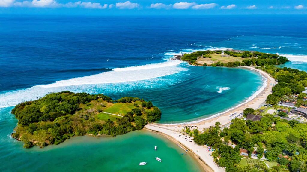 The image shows an aerial view of Peninsula Island and the coastline of Nusa Dua in southern Bali, Indonesia.